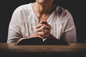 Woman in prayer with open Bible